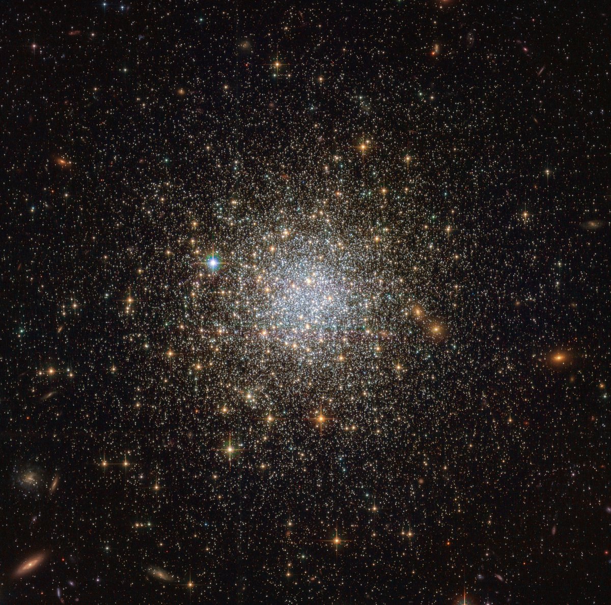 A roughly spherical group of golden stars shines against black space, more closely concentrated at center.