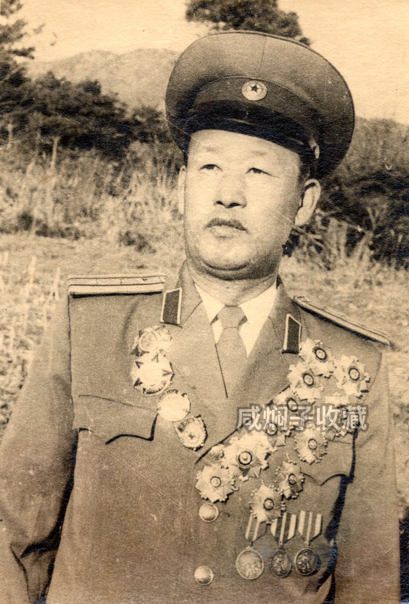 Samcheolli's tweet photo. 🇰🇵 Korean People's Army Colonel's Portrait Set (1980s)  

Original set of three undated portrait photos of an unnamed Colonel of the Korean People’s Army, taken throughout the 1970s to the 1980s.

The first photo was taken when he was still a Lieutenant Colonel while wearing the older style dress uniform. In the second photo, he has been promoted to Colonel and is wearing a newer style dress uniform along with a few additional medals. Even more interesting are the Guards Badge and Red Flag Company (3 Times) Badge he is wearing. The third photo shows him (far left) with his family, where he is wearing a rare long rectangular Kim Il Sung portrait badge and a regular service uniform.