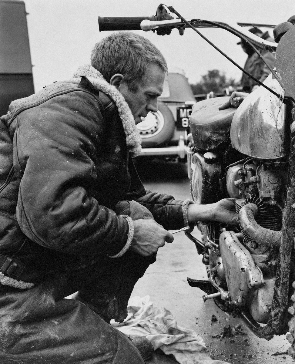 SteveMcQueenPod's tweet photo. Steve McQueen tinkering with a motorcycle while filming the 1962 war film, THE WAR LOVER, based on a novel by the Pulitzer Prize–winning writer John Hersey #SteveMcQueen #Bullitt https://t.co/5dbS8bbgrk