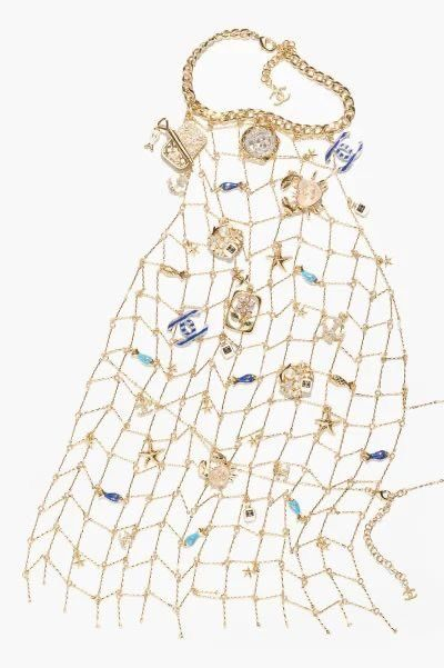 HerodotusWave's tweet photo. An elaborate gold chain and charm net necklace adorned with various coastal-themed trinkets, resembling a fisherman's net design. https://t.co/8tYcMVm8pj