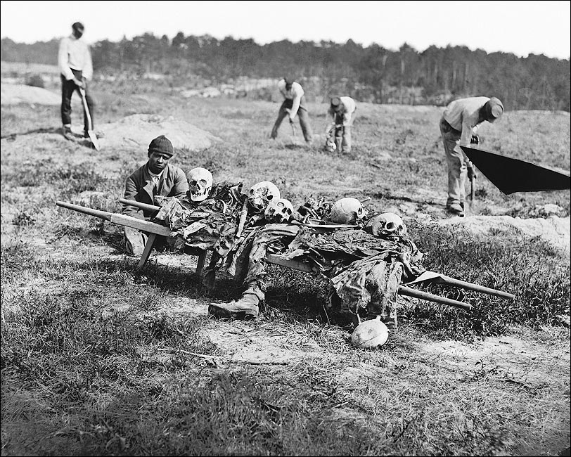 makehistorycool's tweet photo. Virginia. April 1865.

The war was almost over.

But the dead were still waiting to be buried.

Look at this photograph.

An African American Union soldier sits beside a stretcher holding the skeletal remains of men who fought beside him.

Skulls.
Bones.
Pieces of uniforms.

What was left of soldiers who had marched into battle months earlier believing, hoping, praying that they would eventually march home.

They never did.
This was Cold Harbor.

In June 1864, tens of thousands of Union soldiers advanced against Robert E. Lee’s heavily entrenched Confederate army outside Richmond.

The fighting was merciless.

Men were torn apart by rifle and artillery fire. Thousands fell. Some wounded soldiers remained trapped between the lines beneath the Virginia sun because neither army could safely reach them.

And then the armies moved on.

The dead stayed.

Nearly a year later, men were still walking those fields collecting their bones.

That is the part of war we have a tendency to forget.

We remember the charge.

The cannon fire.
The generals.
The flags.
The victory.
The surrender.

We draw arrows across maps and talk about who gained ground and who lost it.

But eventually someone has to walk onto that ground.

Someone has to pick up what is left.

I keep looking at the man in this photograph.

The Union won the Civil War.

He survived it.

So did he win?

Technically, yes.

But look at his face.

Look at what sits in front of him.

War has a strange way of making the word “victory” feel inadequate.

Because every battlefield has two stories.

There is the story of who won.

And there is the story of what it cost.

Lives.
Bodies.
Families.
Friends.

Years of youth that never came back.

And sometimes something harder to photograph, the pieces of a man's spirit that may have been left somewhere on those fields too.

We don't know this soldier's name.

We don't know what he had seen before John Reekie took this photo in April 1865.

We don't know whose skulls rested on that stretcher.

But for one fraction of a second, 160 years ago, the aftermath of war stopped and looked directly into a camera.

No glory.
No monuments.
No speeches.

Just one survivor.

And the remains of the men who didn't