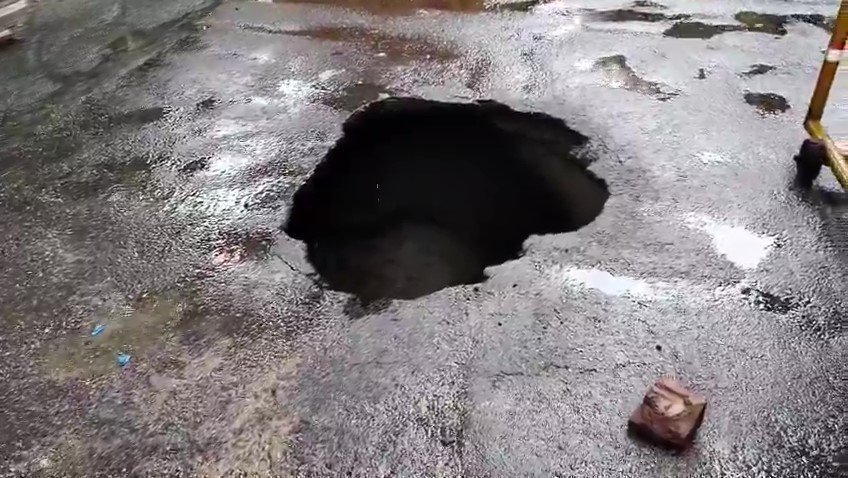Benarasiyaa's tweet photo. This is Lucknow, UP. 

A biker fell into a massive pothole in the middle of the road after the road caved-in following rains. https://t.co/tJQeBZLue7