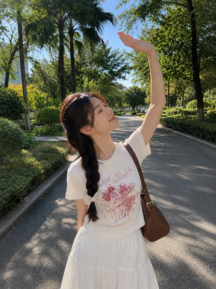 Aqsahere_'s tweet photo. GPT image 2 via @Flovaai

Prompt ↓
A photorealistic outdoor lifestyle portrait of a young woman walking along a peaceful tree-lined park pathway on a bright sunny day. She has long dark hair styled in a neat side braid, secured with a soft cream-colored bow, with a few delicate strands framing her face. She wears small elegant earrings and a simple bracelet.
She is dressed in a casual white graphic T-shirt featuring a delicate red illustration and text, paired with a flowing white tiered skirt. A brown leather shoulder bag hangs naturally from her shoulder. She gently rests one hand against her cheek while tilting her head slightly toward the camera, smiling softly with a sweet, relaxed expression.
The background features a beautiful green park with tall leafy trees, palm-like foliage, neatly trimmed bushes, and a paved pathway extending into the distance. Bright blue sky visible through the tree canopy, warm natural sunlight, soft highlights and dappled shadows, subtle lens flare.
Natural smartphone photography, candid travel aesthetic, realistic skin texture, detailed hair strands, authentic fabric and leather textures, shallow depth of field, soft background bokeh, vibrant yet natural colors, peaceful summer atmosphere, highly photorealistic.