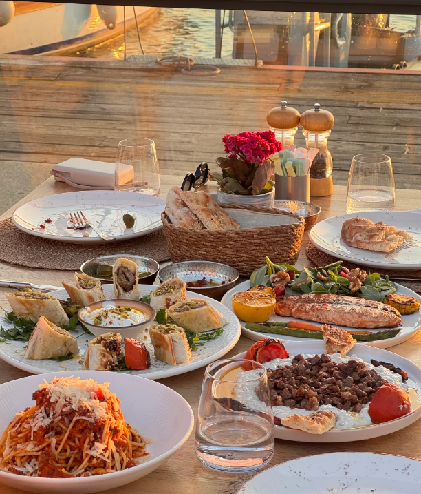 thinker31946746's tweet photo. 滿滿一桌豐盛料理，烤魚肉、特色卷餅、意面搭配奶香蘸醬，香氣十足。吹著晚風享用美食，落日灑在餐桌上，美食與美景同時擁有，氛圍感直接拉滿。

#土耳其美食 #海邊餐廳 https://t.co/V9oCiZduFN
