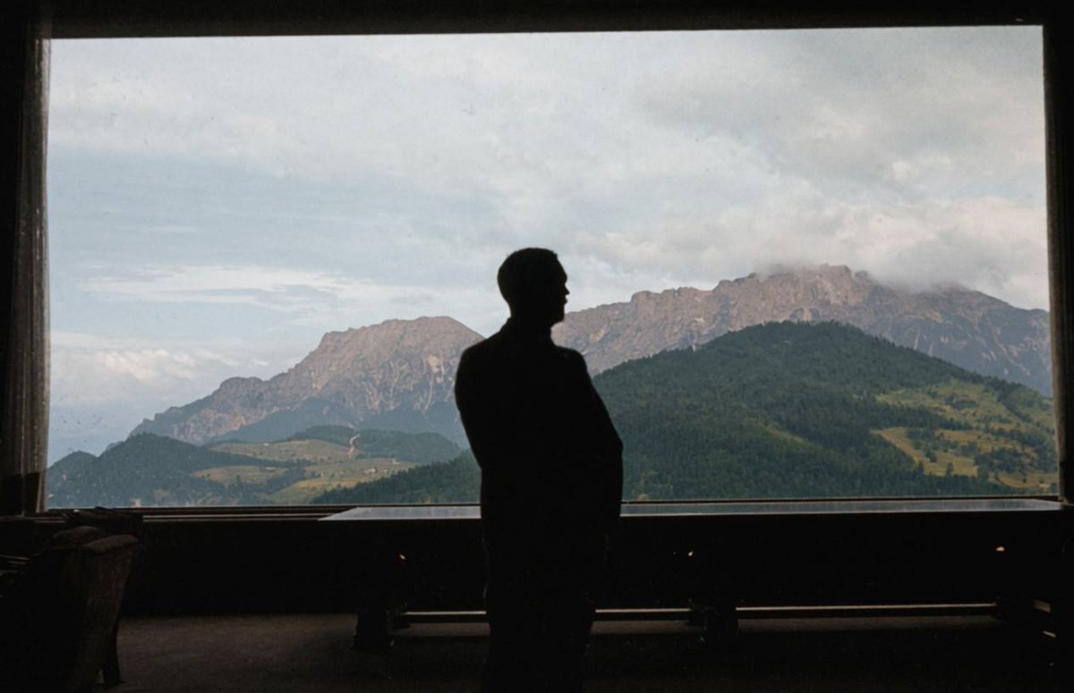 Grimm_717's tweet photo. Photographer Hugo Jaeger captures Adolf Hitler standing in front of the lowered panorama window in the Great Hall of the Berghof, looking across the large conference table at the Untersberg mountain. https://t.co/iyn2hJUKW5