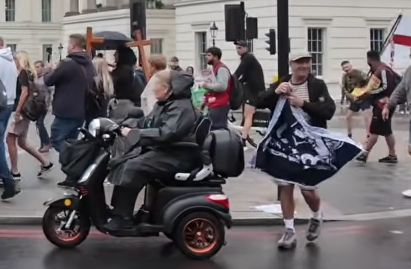 MittensOff's tweet photo. This is London on 22/08/26 just 7 days after the deaths of PCs Matthew Blades and Tom Clough in a collision on the A66 near Middlesbrough. A far-right protester holds A.C.A.B. (All Cops Are Bastards) banner during a UKIP march in central London. I know what he is, but who is he? https://t.co/iiu7hkc253