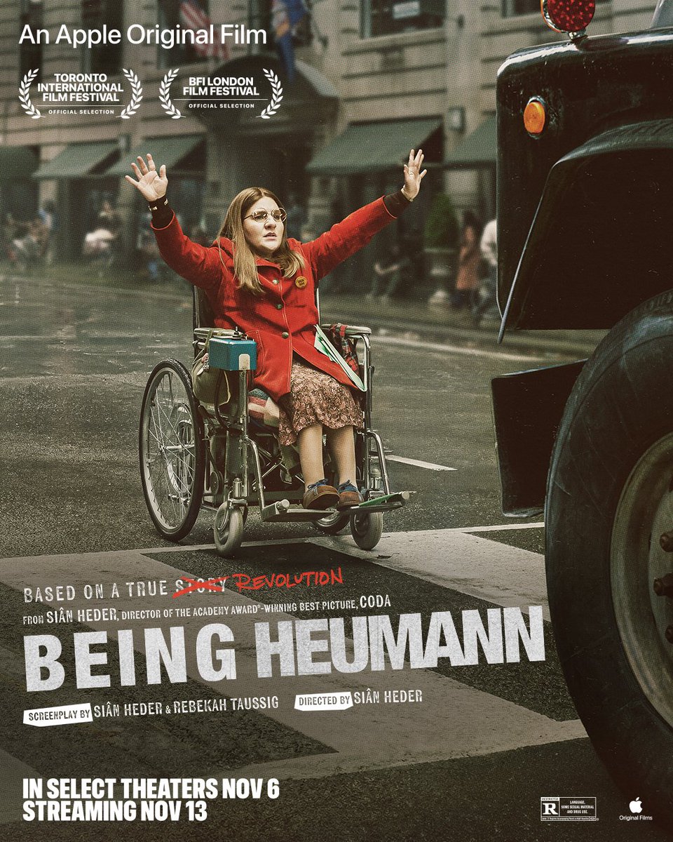 AppleTV's tweet photo. They wouldn’t make way for Judy, so she forged her own path.

#BeingHeumann is in select theaters November 6. Streaming November 13 on Apple TV.

[Image Description: Ruth Madeley as Judy Heumann sits in her wheelchair on a busy street with her hands raised up in protest, as a large car approaches her. Text on the image reads: An Apple Original Film, Toronto International Film Festival, BFI London Film Festival, Based on a true story (but “story” is crossed out and replaced with “revolution”), from Siân Heder, director of the Academy award-winning best picture, CODA, BEING HEUMANN, screenplay by Siân Heder and Rebekah Taussig, directed by Siân Heder, in select theaters Nov 6 streaming Nov 13.]