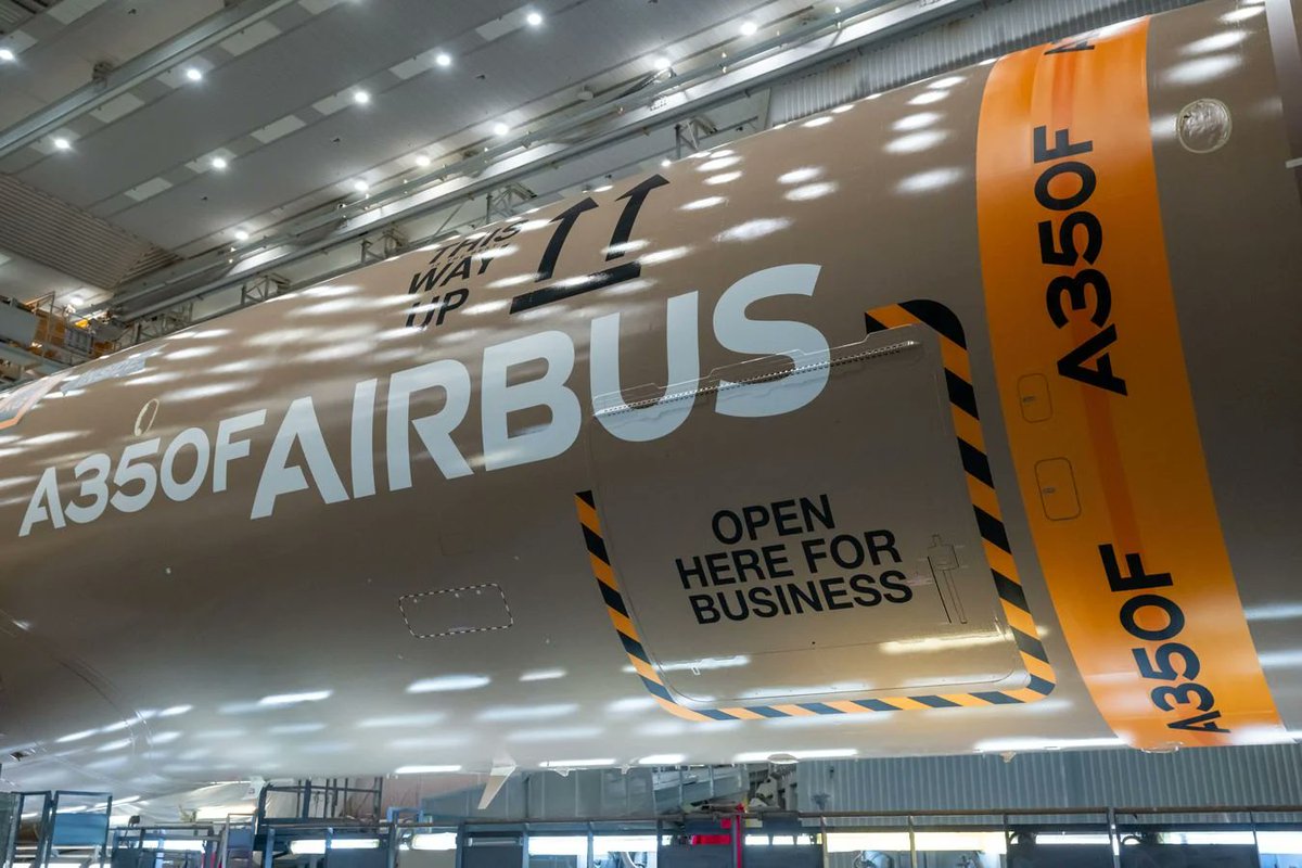 fl360aero's tweet photo. UNPACKING THE A350F’S LIVERY — IT’S MORE TECHNICAL THAN IT LOOKS

The first Airbus A350F has emerged from the paintshop wearing a striking new livery — but behind the graphics is a four-year engineering and manufacturing effort.

Here are some of the technical highlights 👇

🎨 1,000 m² canvas

With almost no passenger windows, the A350F offered designers an enormous canvas. More than 4,000 public submissions were received, with two winning concepts ultimately combined into the final design.

🛩️ 90%+ composite airframe

The A350F is predominantly built from composite materials, which behave differently from metals as temperatures change. Airbus therefore developed a new, more flexible external primer designed to absorb thermal stresses while maintaining adhesion and durability.

⚖️ Paint has a weight penalty

Aircraft paint isn't weightless. A typical A350 paint system can add approximately 400–500 kg of dry-film mass. Engineers therefore had to balance the visual complexity of the livery against strict aircraft weight requirements.

🧩 Paint + adhesive films

Instead of painting every graphic directly, Airbus combined conventional paint with decorative adhesive films. The printed films reduce the number of paint layers, colours and masking operations required — helping cut both weight and painting time.

📦 World’s largest main-deck cargo door

The A350F required a custom paintshop configuration. Engineers developed a dedicated access module and a method to mask/unmask the huge main-deck cargo door without opening it, reducing the risk of damage.

🔴 3D laser anti-collision technology

One of the coolest pieces of technology is hidden inside the paintshop. A digital zero-collision system uses 3D laser mapping and sensors to guide the automated painting platform around the aircraft.

As the platform approaches the fuselage, its movement automatically slows — and it stops completely just 5 cm from the aircraft surface.

📐 Custom infrastructure

The A350F's fuselage length falls between the A350-900 and A350-1000, requiring Airbus engineers to create a custom paintshop setup specifically for the freighter.

🖤 Carbon-fibre identity

The vertical stabiliser features a distinctive carbon-fibre weave graphic, highlighting the A350F’s composite construction and linking it visually with other A350 prototype aircraft.

From public design competition to composite-compatible coatings, automated laser safety systems and weight optimisation, the A350F’s paint job is a fascinating example of where aviation design meets aerospace engineering.

#A350F #Aviation #AviationTechnology #Aerospace #Freighter #Aircraft #CompositeMaterials