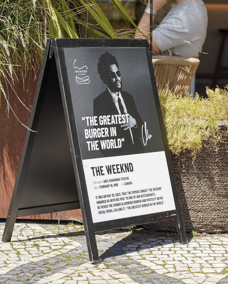 MementoMoriXO's tweet photo. The Weeknd paid a visit after 3 years to Burger Champ in Portugal to eat the “greatest burger in the world” in his own words 🍔🇵🇹  

Separate fun fact: he’s wearing his Persona 6 tee that was gifted to him by the Persona games series illustrator Shigenori Soejima - this tee isn’t even on sale yet!