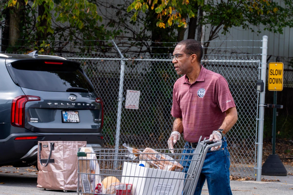 A volunteer pushing a shopping cart