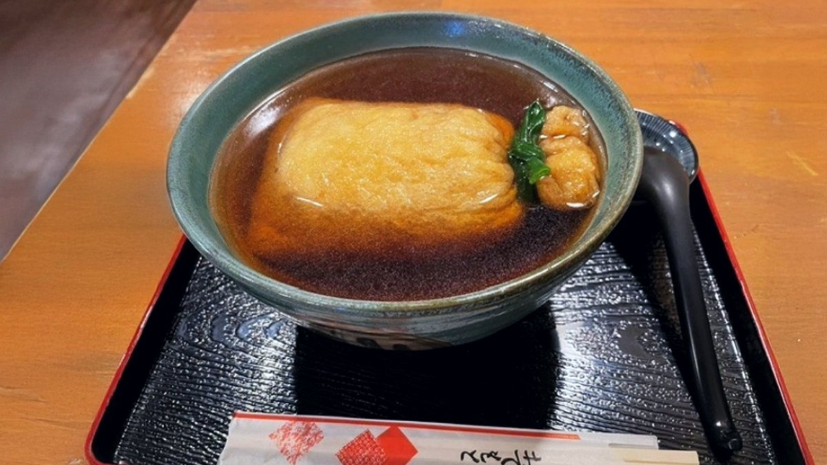 suiki_technos's tweet photo. 奈良への出張でいただいた一杯。

大きな油揚げの巾着が浮かぶ、印象的な見た目です。
さて、この巾着の中には何が入っていると思いますか？🤔

正解は…
 うどん！🍜✨

あっさりとした関西風の出汁の旨味がじんわりと広がり、見た目の楽しさと奥深い味わいを一緒に楽しめる、心温まるご当地メニューでした。