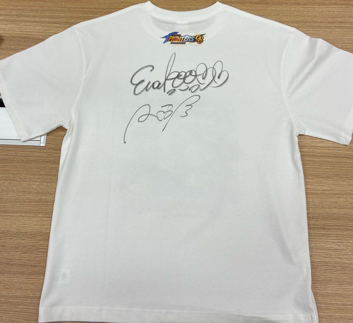 KOF98_IF's tweet photo. こちらは、公式コスプレイヤーのサイン入りTシャツのデザインです！
実際の賞品には、Tシャツの裏面に直筆サインが入ります。
※キャンペーン画像に掲載しているTシャツはサンプル画像となっております。 https://t.co/g4oy8qqVHI