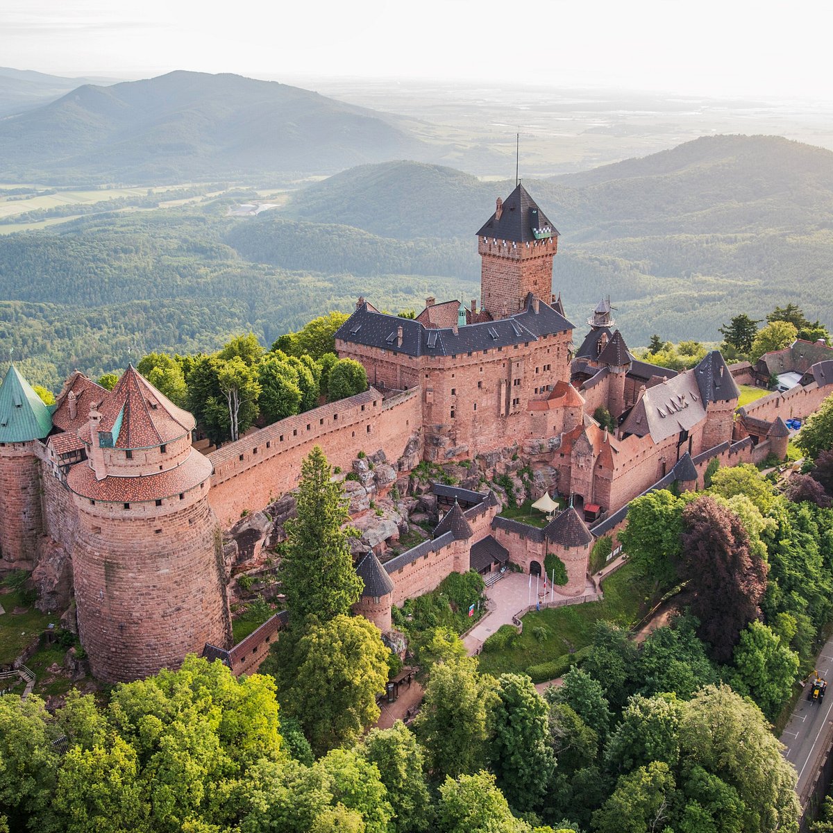 CeJourHistoire's tweet photo. Le château qui domine toute la plaine d'Alsace a été rebâti, pierre par pierre, par l'empereur d'Allemagne.

Il s'appelle le Haut-Kœnigsbourg, le château le plus visité d'Alsace, perché à plus de 700 mètres sur un piton des Vosges, au-dessus de Sélestat.

Pendant près de deux siècles et demi, ce n'était qu'une ruine. En 1633, en pleine guerre de Trente Ans, des troupes suédoises l'assiègent 52 jours, le pillent et l'incendient. Puis la forêt reprend ses murs.

En 1871, l'Allemagne annexe l'Alsace. Et en 1899, la ville de Sélestat offre le tas de pierres à l'empereur Guillaume II.

Lui y voit une occasion. Reconstruire un château médiéval entier, pour prouver aux Alsaciens que leur passé est allemand.

Il confie le chantier à un architecte spécialiste, Bodo Ebhardt, qui relève les tours, refait les toits, remonte le donjon et les grandes salles. Huit ans de travaux. L'empereur l'inaugure en personne en 1908.

Onze ans plus tard, l'Alsace redevient française, et le château avec elle.

Aujourd'hui, plus de 500 000 personnes montent chaque année visiter ce Moyen Âge rêvé par un empereur allemand, sur une terre redevenue française.