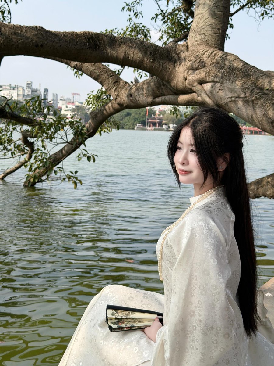 Mia_Linh01's tweet photo. Một góc nghiêng bên bờ hồ, tà áo dài trắng khẽ bay trong gió, phía xa là cành cây nhô ra mặt nước nhìn nên thơ đến lạ 🤍🍃✨

Khung cảnh dịu nhẹ như chậm lại một nhịp, mọi thứ yên ắng vừa đủ để mình cảm nhận được chút bình yên rất riêng của khoảnh khắc này 🤭💛

Chỉ cần một chiếc áo dài trắng, một góc hồ thật xinh và chút nắng nhẹ thôi là cũng đủ làm nên một bức ảnh đầy cảm xúc rồi nè 🌿📸

Mọi người thấy góc này có dịu dàng và nên thơ không ạaa? 🥰✨