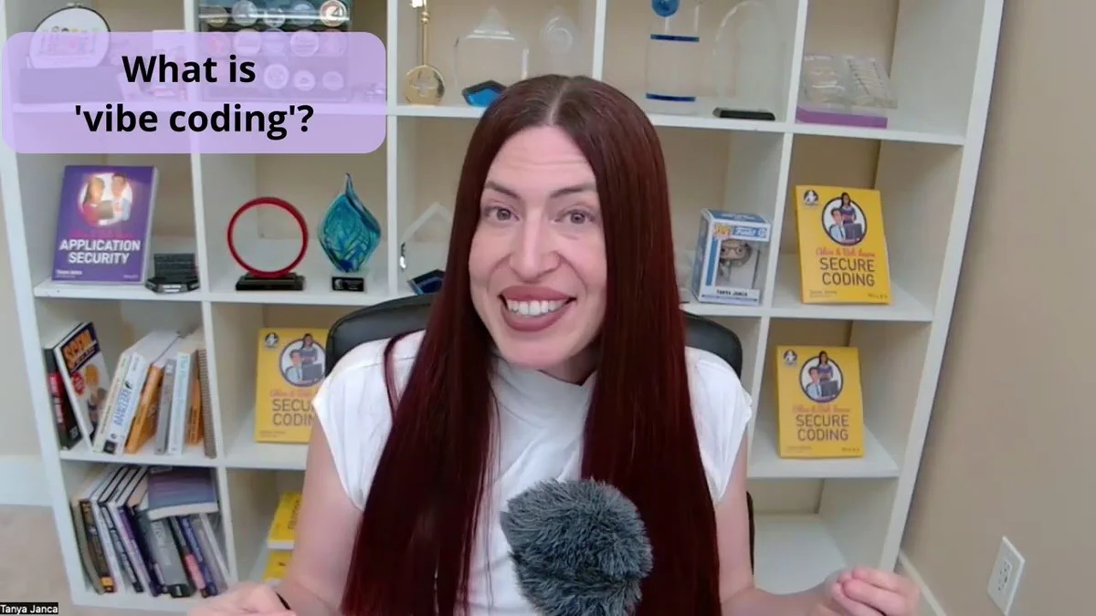 A woman with long dark red hair speaks in a home office, seated in front of white shelves with books and awards, including several titled Secure Coding and Application Security. A purple text box reads What is vibe coding? and a name label at the bottom left says Tanya Janca.