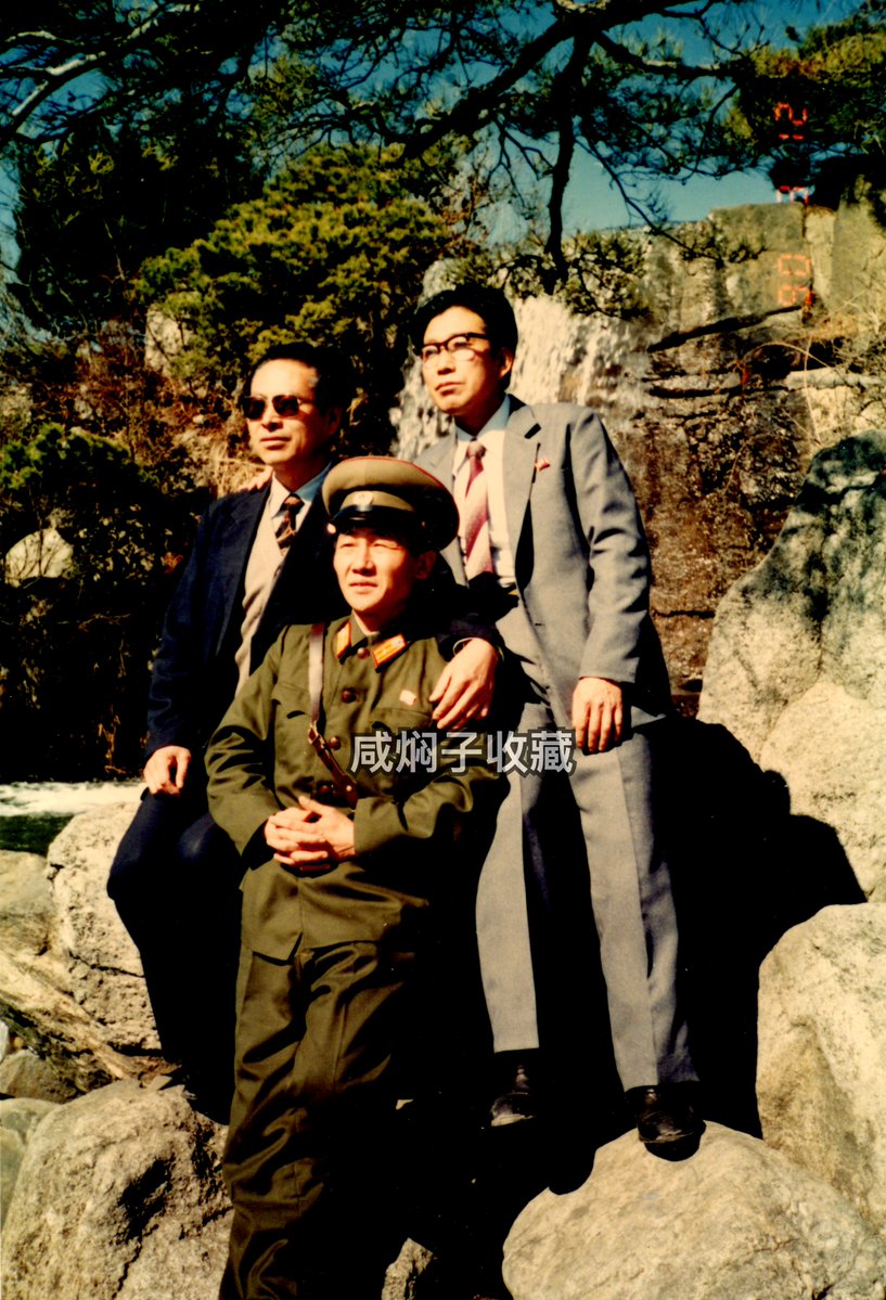 Samcheolli's tweet photo. 🇰🇵 Korean People's Army Major's Photo (1990) 

Original colour photo of an unnamed Major of the Korean People's Army with two other unidentified men, dated March 12th 1990.