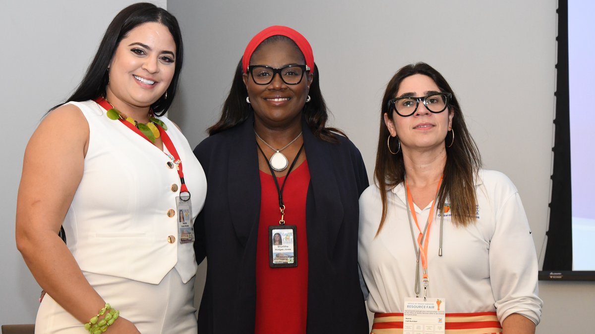 The Tenant Services team stands smiling and facing the camera on the stage of the Orange County Multicultural Center.
