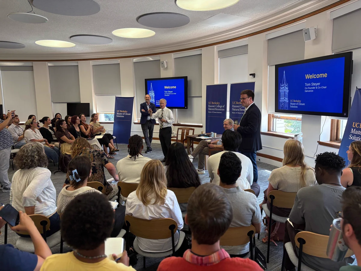 Audience seated in a curved classroom listening to Chancellor Rich Lyons at the front, with UC Berkeley Master of Climate Solutions banners and a large screen displaying a welcome slide for a guest speaker.