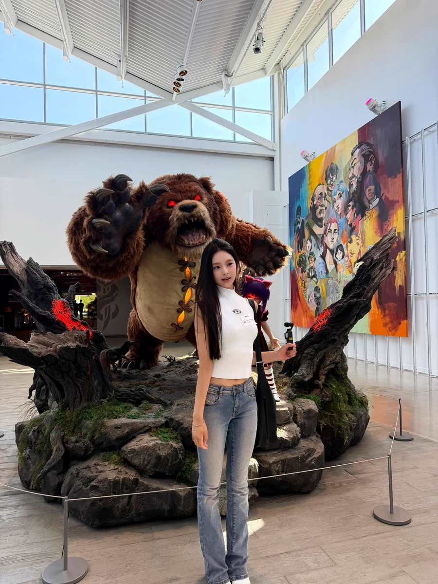 An idol from the K-pop band AtHeart poses in front of the Annie and Tibbers statue at Riot’s Los Angeles Headquarters. 

