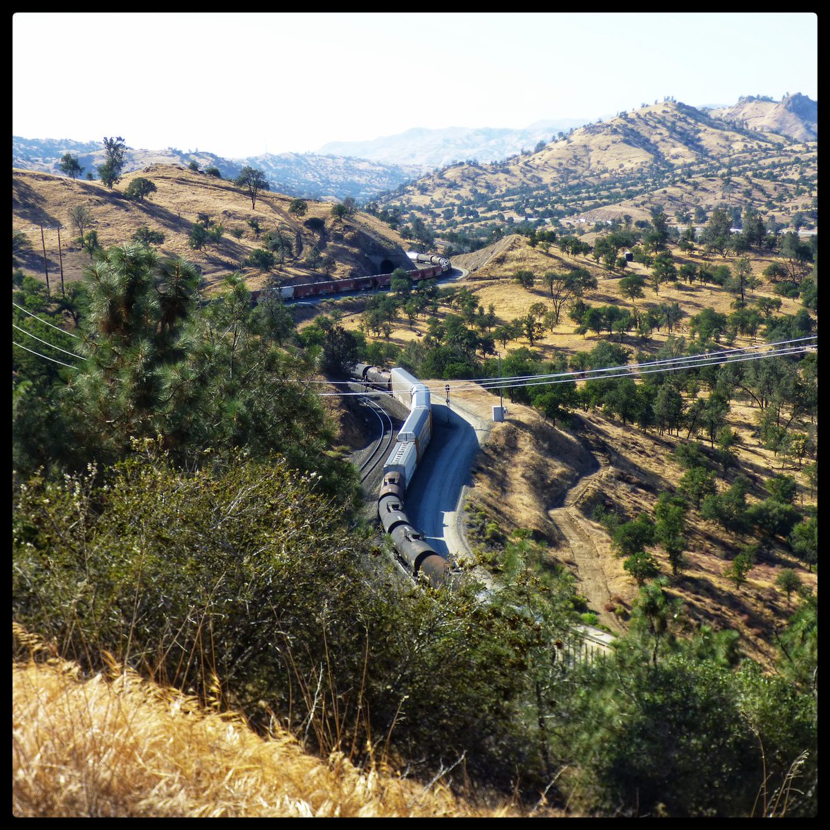 SamuelBarrpn6's tweet photo. The Tehachapi Loop, built 1874–1876, is a railway engineering wonder. Its ¾-mile granite track climbs 77 feet at a 2% grade, allowing 4, 000-foot trains to pass over themselves. Designed by William Hood, it remains active today. https://t.co/ukW3GOTEmj