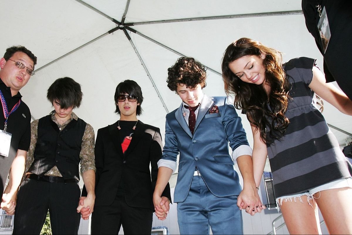 johnmainw's tweet photo. jonas brothers e miley cyrus fazendo uma oração antes de uma apresentação em 2008 https://t.co/vfE2uD1U50