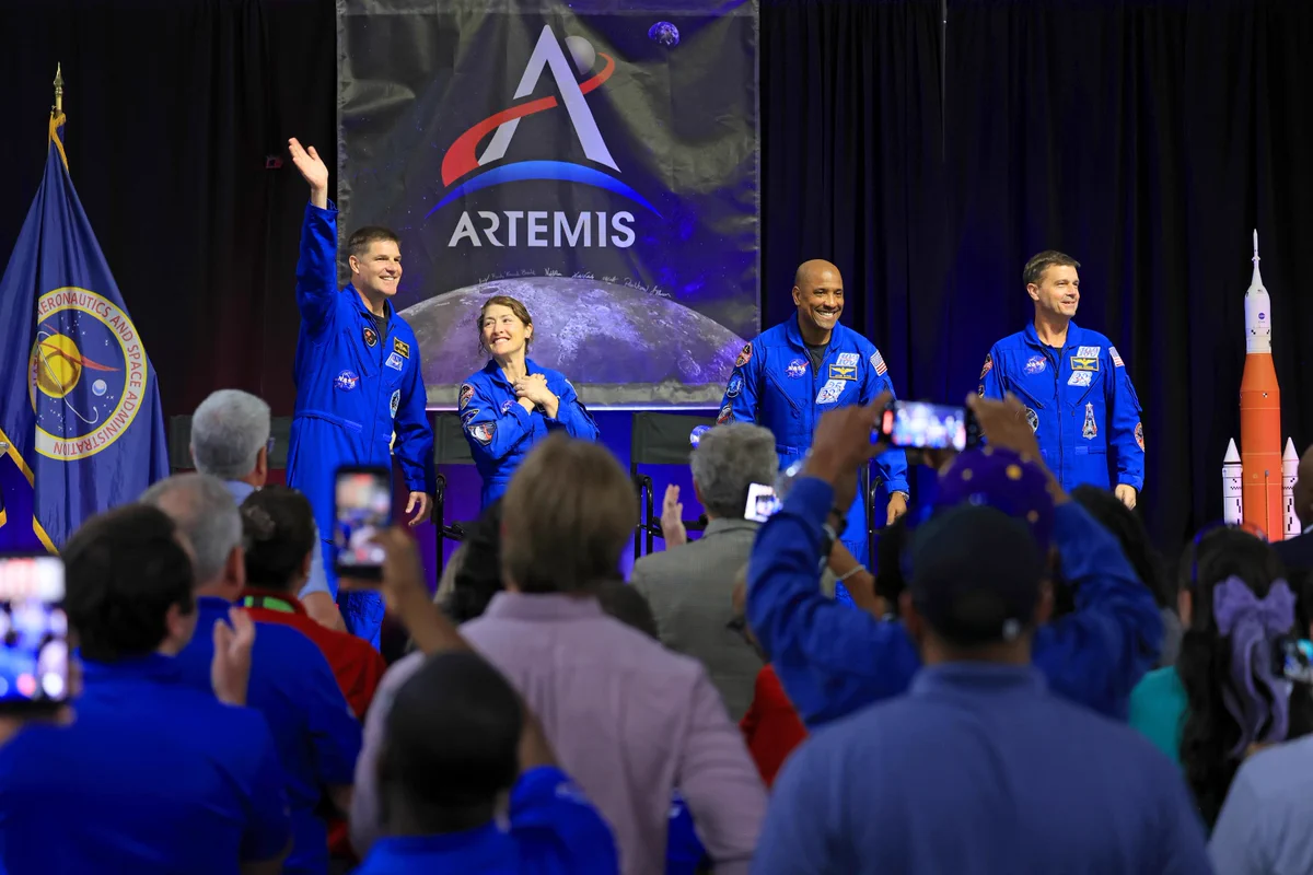 The Artemis II crew stand on a stage and wave to a crowd of employees at NASA Michoud during a visit. Credit: NASA/Michael DeMocker