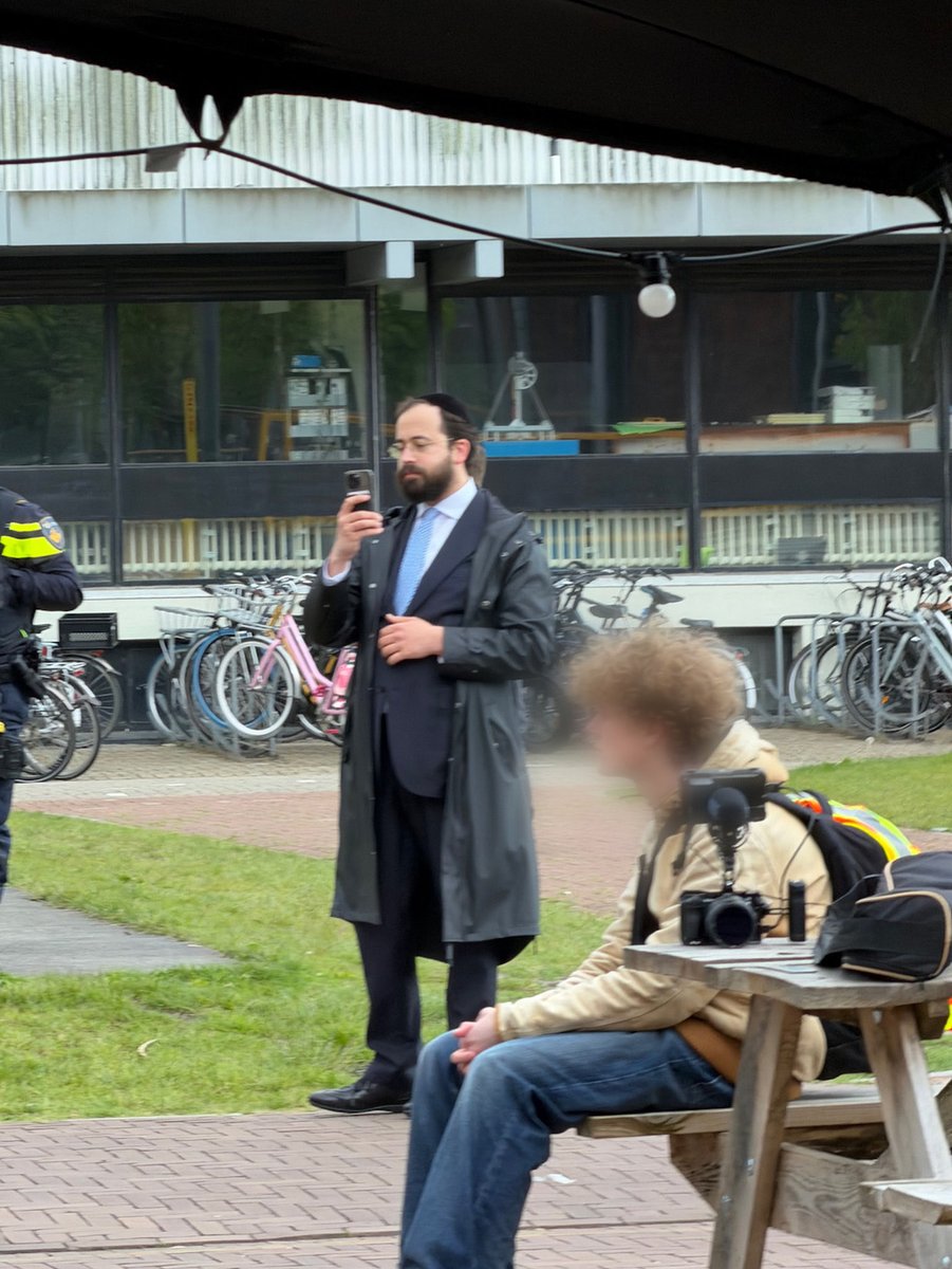 _WMedia_'s tweet photo. "En natuurlijk moeten ze dat vrij en veilig kunnen doen." @MinPres 

Uiteraard, maar dat geldt voor alle studenten.

De man op de foto met Rob Jetten is studentenrabbijn Yanki Jabobs. Op 18 mei 2026 stond hij op de VU-campus opnames van studenten te maken die demonstreerden voor het Palestijnse volk. 

Dezelfde Jacobs zei in 2024 tegen het RD dat het demonstratierecht op universiteiten niet geldt en noemde pro-Palestijnse studenten, waaronder Joodse studenten, propagandapionnen.

Vier universitaire docenten schreven in februari in NRC dat “studentenrabbijn” geen officiële functie is en dat Jacobs niet namens de Joodse studenten spreekt. Ze waarschuwen in datzelfde stuk tegen het bespieden van studentenactiviteiten. 

Onderstaande foto is daar een voorbeeld van. Foto: VU Amsterdam, 18 mei 2026. Whispering Media

https://t.co/tUztHwvcKb