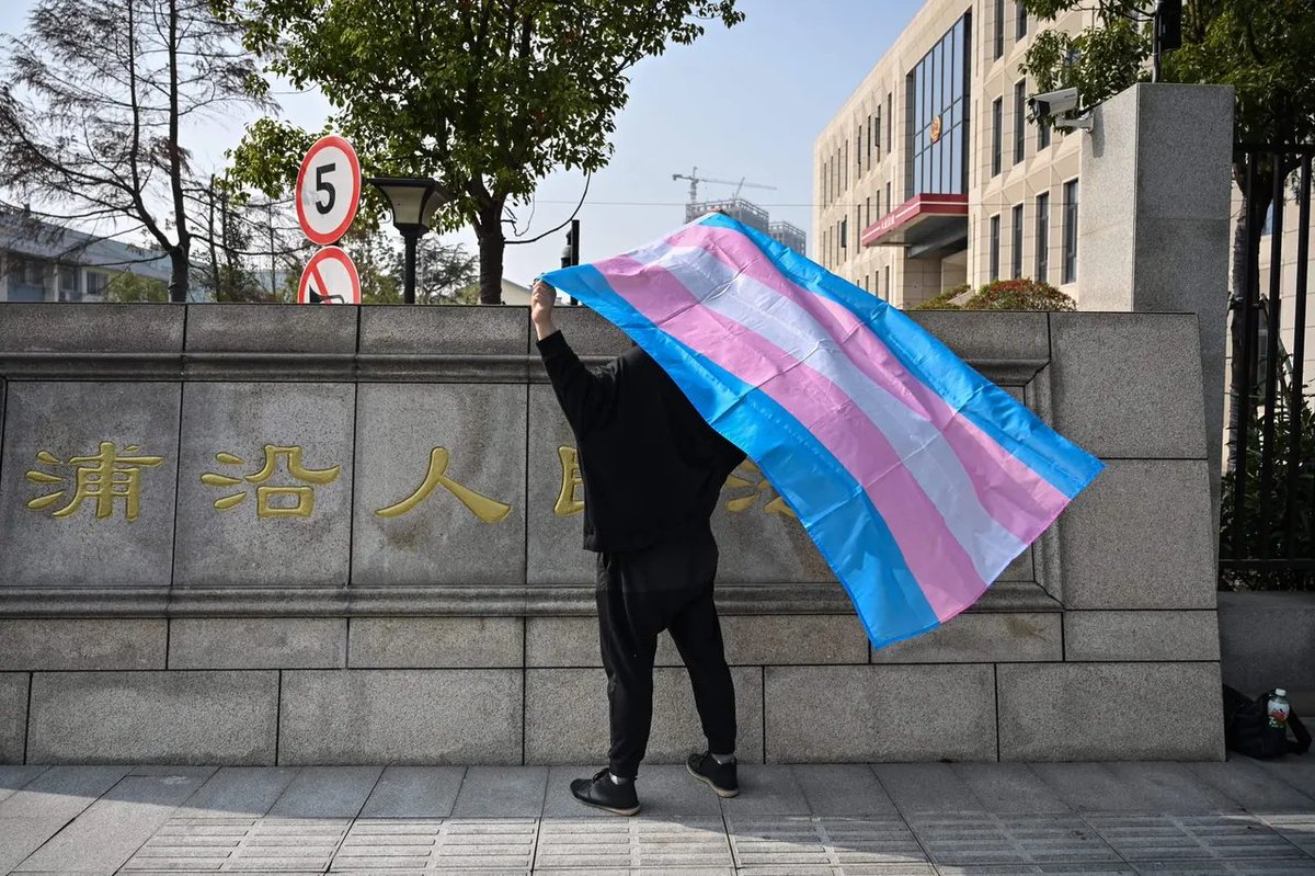 zza2ku's tweet photo. 2019年12月3日，杭州，一名跨性别女性在法院外身披跨旗 https://t.co/waLn4PYGGM