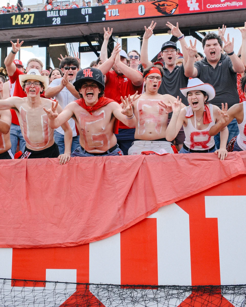 The Bleacher Creatures flashing their Cougar paws at TDECU Stadium.