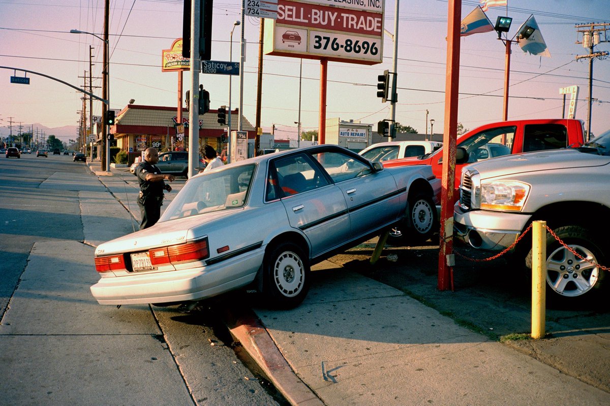 NewYorker's tweet photo. In his photographs, the skateboarder Jerry Hsu captures Los Angeles’s manic extremes. He maps a city of leftovers and castoffs; portraits of friends and strangers in the street are full of dazed, inscrutable expressions. Many of his images, even the faintly violent ones, possess an absurdist humor. “Maybe this is corny,” Hsu said, “but all this chaos and these little beautiful secrets I found here reminded me of myself.” See more of his photos: https://t.co/T5AjVmEC6E
