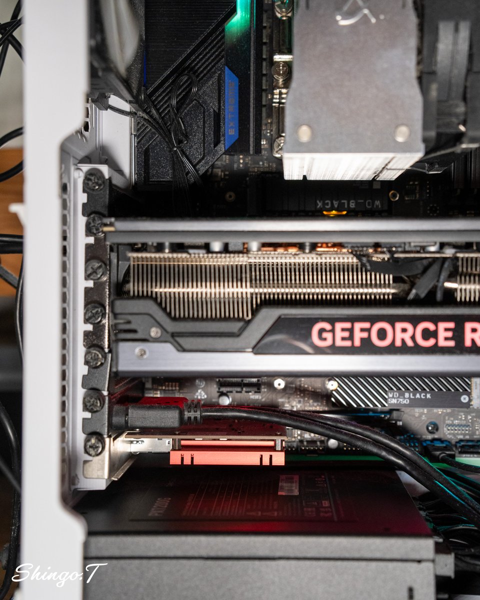 shingo1228's tweet photo. RTX4090 24GBが分厚すぎて、直下のPCIeスロット（PCIE2）が完全に塞がれている今のPC。
一方、手元には玉突きで余り、実家に持って行ったRTX3060 12GB。
12GBものVRAMを帰省した時に使えるとは言え眠らせておくのは何となくもったいない。

使用中のマザーボード ASRock Z690 Extreme WiFi 6EのPCIeスロットの構成から、4090はGen5 x16から動かしたくないので、最下段のGen3 x4に3060を刺したい。でも今のケースでは2スロット厚が物理的に入らない。

そこで気になっている最近見かけたThermaltake AX500。
リア拡張スロットが8段あるので、7段目のPCIE4＋余剰の8段目を使えば、4090を動かさず3060も2枚刺しできるのでは。。。？
実用性というより、「手持ちのリソースを全部使い切りたい」というロマンが勝ちつつある。。。