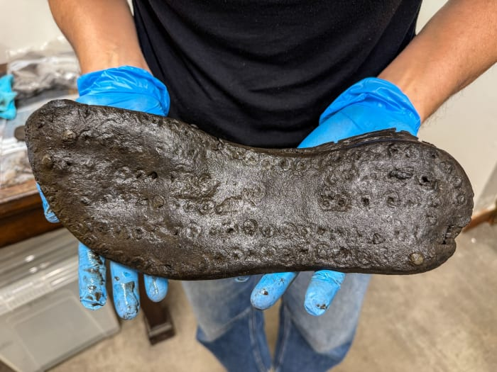 RomanBritainHQ's tweet photo. The ground that preserved Magna’s Roman shoes is drying out.
This leather shoe from Magna Roman Fort on Hadrian’s Wall survived in a low-oxygen ditch. But parts of the waterlogged ground that protected fragile organic remains are drying and becoming exposed to more oxygen.

I find that genuinely unnerving. Once oxygen reaches these deposits, microbes and fungi can start breaking down leather, wood and other organic evidence again.

The Vindolanda Trust made a decision I really admire: don’t simply race to dig. Measure the ground.

Its Wall-E probe array records moisture, temperature, acidity and oxygen conditions every 15 minutes. Geoarchaeologist Franki Gillis and Dr Gillian Taylor are among the specialists turning those readings into preservation strategies.

The warning is visible in the trench. Some shoes have survived with uppers and decoration. Other leather has come out dry and brittle, or decayed until only a dark fibrous trace remained.

That contrast is what I can’t stop thinking about.

Crucially, the team is not claiming every damaged object proves modern climate change. The latest monitoring shows a repeating seasonal swing between oxygen-rich and low-oxygen soil, and the cause of that pattern is still not pinned down.

Nearly 250 volunteers are helping excavate Magna this season. The project’s real end point is not a trophy case, but a management plan for what can safely stay buried and what needs intervention.

I love that. The rescue is keeping Roman Britain readable before the evidence disappears.