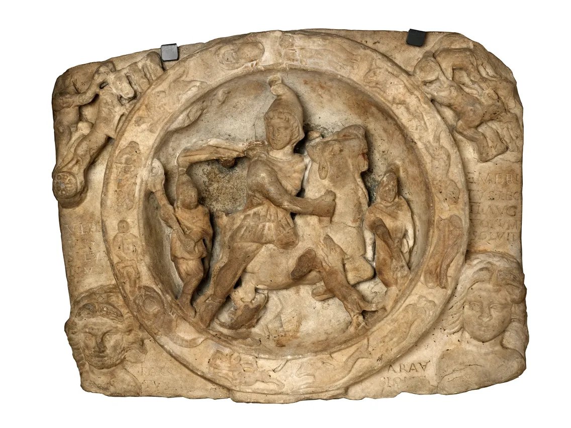 RomanBritainHQ's tweet photo. This marble head appeared on the final day — then London queued

The archaeologists at Walbrook had reached the end of their dig.

Beneath the bomb-damaged City of London, they had uncovered a substantial Roman stone building. An altar suggested religion, but they still could not say exactly what the place had been. New offices were due to rise above it, and the excavation was almost over.

Then, on the final day in 1954, a marble head came out of the rubble.

The youthful face had thick curls and the distinctive cap associated with Mithras. Suddenly the building had an identity. This was a mithraeum, a temple used by followers of the mysterious Roman god Mithras.

The timing could hardly have been more dramatic. The dig was meant to finish. The modern development still had to go ahead.

But photographs of the discovery reached the Sunday newspapers, and the buried temple became a public sensation.

Tens of thousands of people queued to see it. In a London still marked by wartime destruction, crowds waited for the chance to peer down at Roman walls exposed between modern buildings. The pressure became political, and Winston Churchill backed extra time for the excavation.

The temple had probably been built around AD 240, close to the Walbrook stream. Its followers left no surviving handbook explaining exactly what happened inside. The sculptures and the building tell us that Mithras mattered here, but much about the worship itself remains uncertain.

The marble head was only part of the surprise. Archaeologists also recovered an exceptional group of Roman sculptures from the site, including images of other gods.

The public campaign did not freeze the temple in place forever. Its remains were lifted and reconstructed about 100 metres away. Decades later, when the Bloomberg development brought archaeologists back to Walbrook, the stones were moved again and the temple was reconstructed underground, close to where Roman Londoners had used it.

That is what makes the 1954 moment so extraordinary.

A building nobody could yet name was close to being dismantled for the next London development. Then, on the very last day, one marble face emerged from the ground — and tens of thousands of people queued to see what it had revealed.
