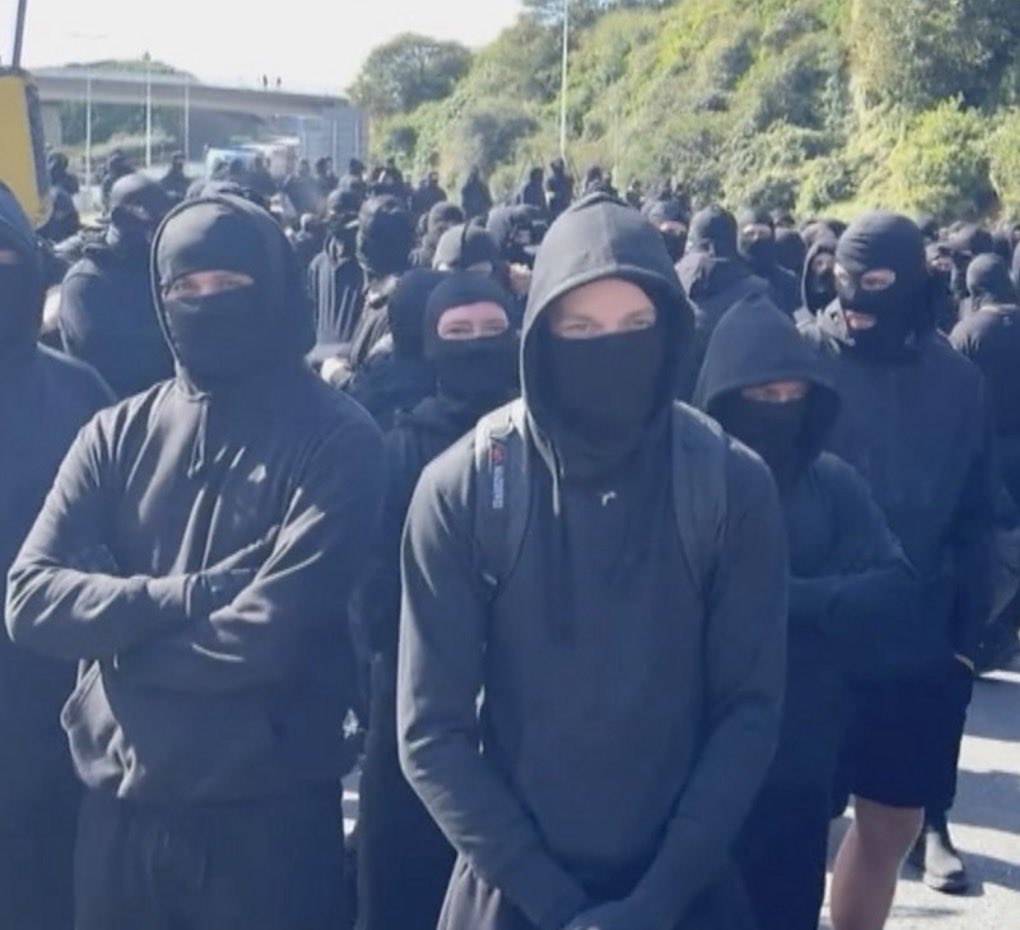 technopopulist's tweet photo. People are missing the point entirely about the masked men in Dover. The purpose of the protest was not to inflict violence. It was to test the waters around new OPSEC.

English nationalists, as I predicted long ago, are slowly adopting the operational methods associated with Northern Irish Catholics and Protestants during the Troubles. At the moment, they are doing it in a piecemeal, amateurish and often cringe-worthy fashion. But that is what is happening.

They are doing this because they have given up on democracy and concluded that vigilantism and direct action are more effective routes to political change. They have also witnessed what happens to anti-migrant protesters with poor OPSEC: job losses, imprisonment and ostracism.

The Dover incident is therefore highly significant. It demonstrates that sections of the population have given up on democratic protest and are experimenting with clandestine methods of political mobilisation. That is laying the groundwork for more controversial and potentially dangerous forms of action in the future.

This is an observation about political behaviour, not an endorsement of it.