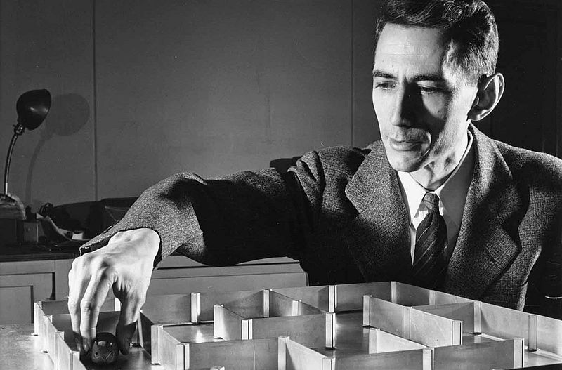 mathemetica's tweet photo. Theseus, the mouse.

In 1950, Claude Shannon and his wife Betty sat on their living room floor and built a machine that could remember.

They named it Theseus - a little mechanical mouse that wandered a maze, bumped into walls, tried again, and eventually found the goal. The first time through, it was all trial and error. After that, something quietly astonishing happened: it never forgot.

Place Theseus anywhere it had already been, and it would go straight there. Drop it in a new stretch of corridor and it would explore until it recognized familiar ground, then add that new piece to its memory and keep going. Rearrange the walls, and it would start over - patiently learning the new layout.

The “brain” wasn’t inside the mouse. It lived underneath the maze: a network of telephone relays that stored every successful turn. Shannon called it a toy. History has been less modest. Many now see Theseus as one of the first machines that actually learned from experience.

The original maze is still at the MIT Museum.

Mazin Gilbert put it simply: Theseus “inspired the whole field of AI. This random trial and error is the foundation of artificial intelligence.”