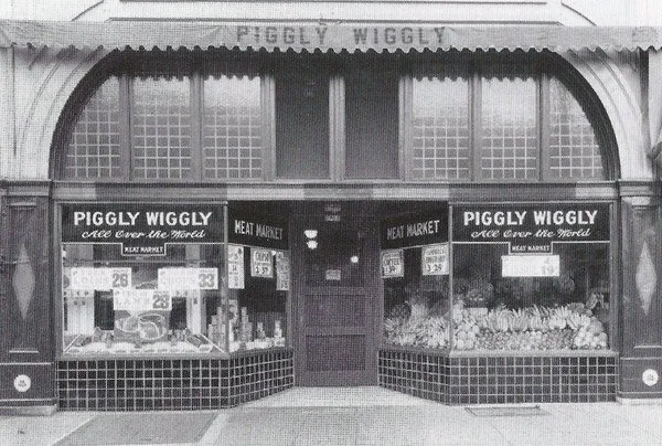 EchoesofWarYT's tweet photo. September 6, 1916. The first true self service grocery store, called Piggly Wiggly, opened in Memphis, and it completely changed the way people shop for food.

Before this, buying groceries was a slow, personal process. You handed a clerk your list, and he went around the store gathering everything for you while you waited. It was inefficient, required lots of staff, and gave shoppers no chance to browse.

A businessman named Clarence Saunders had a radical idea. What if customers just walked through the aisles themselves, picked their own items off the shelves, and carried them to a checkout counter at the front. He put price tags on everything and let people serve themselves.

It sounds completely ordinary now, because it became the model for virtually every supermarket on earth. Aisles, shelves you browse, a basket you fill, a checkout line at the end, all of it grew from this store. The entire modern shopping experience was invented when Piggly Wiggly opened its doors on this day.