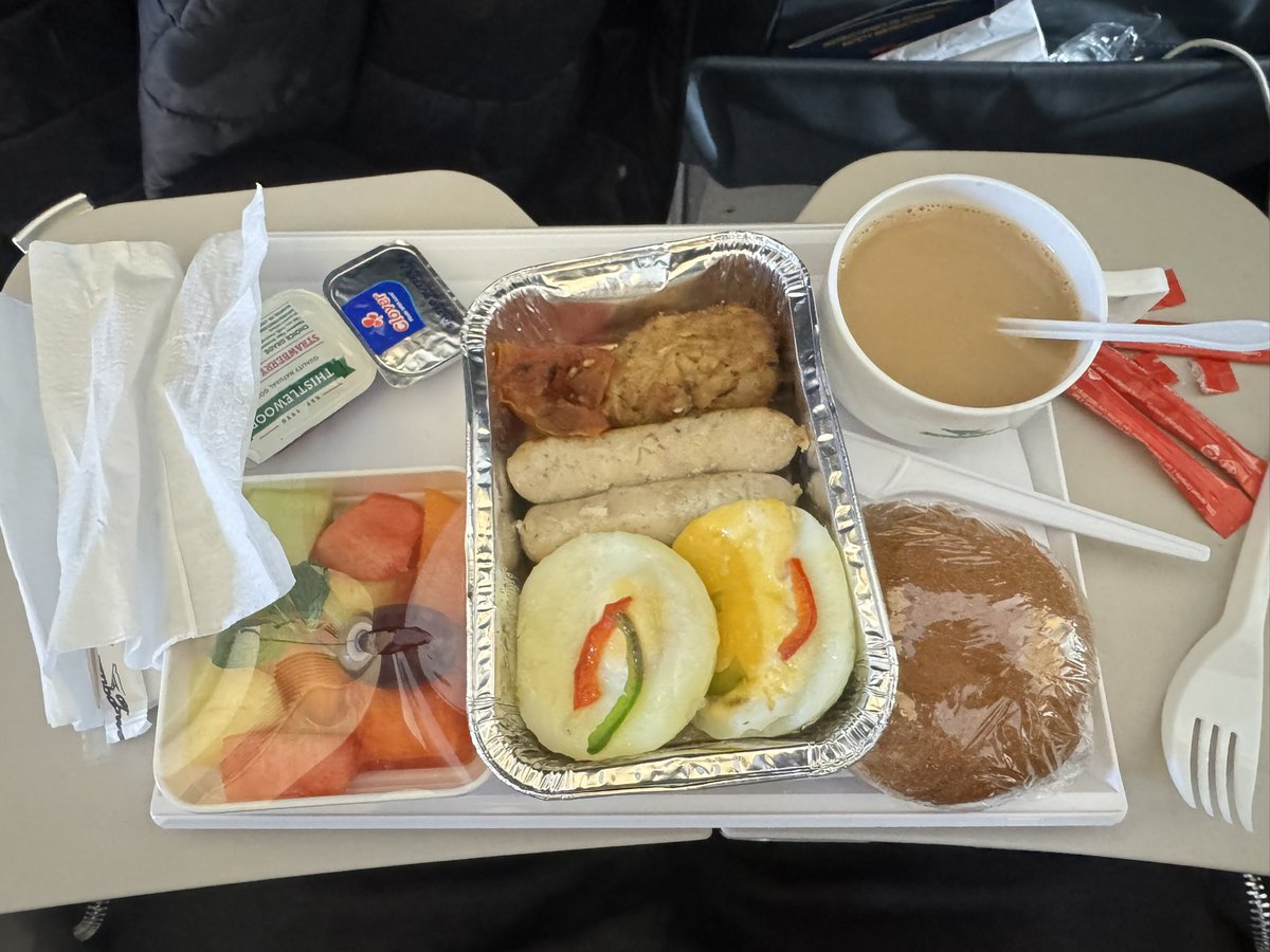 KingJayZim's tweet photo. #SoulShackRadio ✍🏽 @TeamFuloZim 
Sorry @FlyAirZimbabwe, it’s me again… your greatest cheerleader. 😂😂

Real friends tell each other the truth, and I genuinely believe we seriously need to sit down and have a conversation about revamping the meals served on our national airline.

After my earlier post about the sadza and #HighFiridzi dish, I now have another issue.

Breakfast! 😩😂

Surely, we can do better than this.
Let’s start with those sausages. At least give them a bit of colour! Brown them nicely, give them that gloss, that caramelised finish which makes food appealing to the eye.

As our Chef de Cuisine at @TeamFuloZim, @Vie_matongo always says:
“We eat with our eyes first.”
Those sausages look anaemic. 😭😂 They desperately need a tan! 

They look like they were cooked, frozen, then defrosted moments before take-off. Please, at least let them catch a bit of colour!

Then there are the eggs.
I had to zoom into the photograph about three times trying to establish exactly what was going on there. 😂😂

Are they poached? Fried? One appears slightly underdone while the other looks like it had a completely different experience in the kitchen.

Consistency, please. If you're serving two eggs on the same plate, surely they should look like they came from the same kitchen and were cooked by the same chef! 😭

Now, tucked away in the corner, I think I can see bacon.
If that is indeed bacon, then my goodness… that thing has been through the fire! 😂😂

I like my bacon crunchy, but not cremated. That looks dry and brittle enough to snap in half before the passenger has even opened the foil container.

Personally, I would substitute the back bacon with streaky bacon. It gives you that lovely colour, the perfect crunch and, when done properly, finishes a breakfast beautifully.

Then there is that mysterious dollop next to the bacon…
I tried to identify it.
I failed.
So I’m leaving that one alone. 😂😂😂

Now, as Chairman of @TeamFuloZim, I’m going to put my money where my mouth is.
I will ask our Chef, Vie Matongo, together with @Lialarsen to prepare the two meals we have been talking about and package them in exactly the same type of containers.
I don’t simply want to criticise,let’s find solutions together.
Hold tight while the ladies do their thing, and we will post their takes right here.

Because at the end of the day, presentation matters,just the same taste.

And passengers matter.
Mbombela passengers are just as important as Business Class passengers. Musadaro! 😂😂
Come on @FlyAirZimbabwe, I’m still your cheerleader… Pachedu.