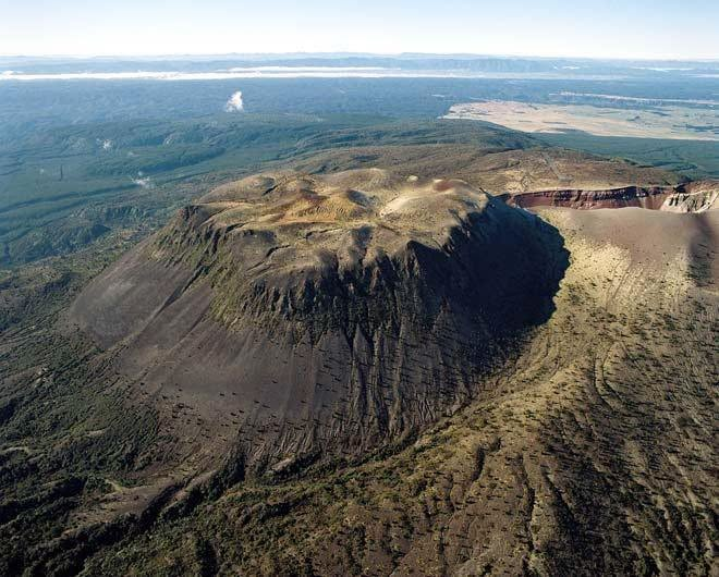vulcaniya's tweet photo. Okataina, Bay of Plenty, New Zealand, 7 September 2026

The rift across the top of Mount Tarawera is easy to see from the air, a line of craters cut through the flat summit and running on to the south-west. It was opened in about four hours on the morning of 10 June 1886, and what it cut through is the point. The mountain it split was itself only about five and a half centuries old, and it stands inside a far older structure, the Okataina volcanic centre, where the ground has been built up, blown apart and built up again for hundreds of thousands of years.

Okataina lies at the eastern side of the Taupo Volcanic Zone and is overwhelmingly rhyolitic. Its main collapse structure, the Haroharo caldera, measures roughly 16 by 26 kilometres and did not form in one event. It developed in stages between about 300,000 and 50,000 years ago, the last major subsidence accompanying the eruption of more than a hundred cubic kilometres of Rotoiti pyroclastics, an episode dated at either around 50,000 or around 65,000 years ago depending on which technique is preferred. That disagreement has not been resolved and is worth carrying rather than tidying away.

Almost none of this is visible on the ground, because the centre has spent the time since burying it. The oldest rocks exposed on the caldera floor are only about 22,000 years old. Since then more than eighty cubic kilometres of rhyolite has erupted from over forty vents, in around eleven separate episodes, filling the depression with domes, lava flows and pyroclastic deposits. The vents fall into two roughly parallel lines running north-east, and the piles they have built are the Haroharo complex in the north and Tarawera in the south. Neither is a volcano beside a caldera. Both are volcanoes inside one.

The lakes came out of that filling. As the two complexes grew they blocked drainage around the older margins, ponding water into Rotoiti, Rotoehu, Okataina and Tarawera. The lakes that make this one of the more agreeable parts of New Zealand to live beside sit where they do because volcanoes built dams across the valleys.

Tarawera's summit is younger still. The Kaharoa eruption, beginning around 1314 and continuing on and off for several years, produced roughly five cubic kilometres of rhyolitic tephra and a further two and a half of lava, building or enlarging the domes of Wahanga, Ruawahia and Tarawera itself. The ash it spread across the North Island is now one of the most useful layers in New Zealand archaeology, since it fell at about the time Polynesian settlement was under way and separates what came before from what came after.

The 1886 eruption was a different kind of event entirely. The magma that rose beneath Tarawera was basalt, not rhyolite, and it came up fast and gas-rich, tearing a line of vents through domes made of quite different rock. About 0.7 cubic kilometres of basaltic magma erupted in some four hours. The fissure did not stop at the mountain. It ran on for about seventeen kilometres, south-west through Lake Rotomahana and into what is now Waimangu. In the crater walls the sequence is plain: pale Kaharoa rhyolite underneath, red and black 1886 scoria on top, one generation of volcanism laid open by the next.

Where the rift crossed Rotomahana it met hot, water-saturated ground, and the explosions there did most of the killing. The villages around the lake, home to Tūhourangi and Ngāti Rangitihi, were buried or destroyed outright. Te Wairoa, further off behind a ridge, lost much of its structure and seventeen of its people, and was never rebuilt. The Pink and White Terraces, the country's best-known attraction, which Tūhourangi families had guided visitors to by boat for years, went with the lake. Death tolls are usually given as around 120, though Te Arawa accounts and later assessments put the figure higher, and it has never been settled. The survivors moved west and many of their descendants live at Whakarewarewa still, some of them guiding.

Rotomahana came back as something else. With its outlet blocked and its basin blasted out, the lake refilled to a level somewhere between 35 and 48 metres above the old one, several times the former area and far deeper. Survey work on the floor of the enlarged lake has since recovered features associated with the terraces, drowned rather than wholly destroyed.

Waimangu, at the far end of the rift, became a hydrothermal field afterwards, and steam-driven explosions have continued to rework it, including a geyser that performed between 1900 and 1904, a small eruption at Raupo Pond in 1981 and renewed activity at the Mud Rift in 2016. None of that is magma arriving. The last magmatic eruption here remains 1886, and GeoNet keeps the centre under watch. The craters on the summit are filling in slowly with scrub, and the pale rhyolite still shows in their walls beneath the scoria.

Vulcaniya | Volcanoes • People • Planet