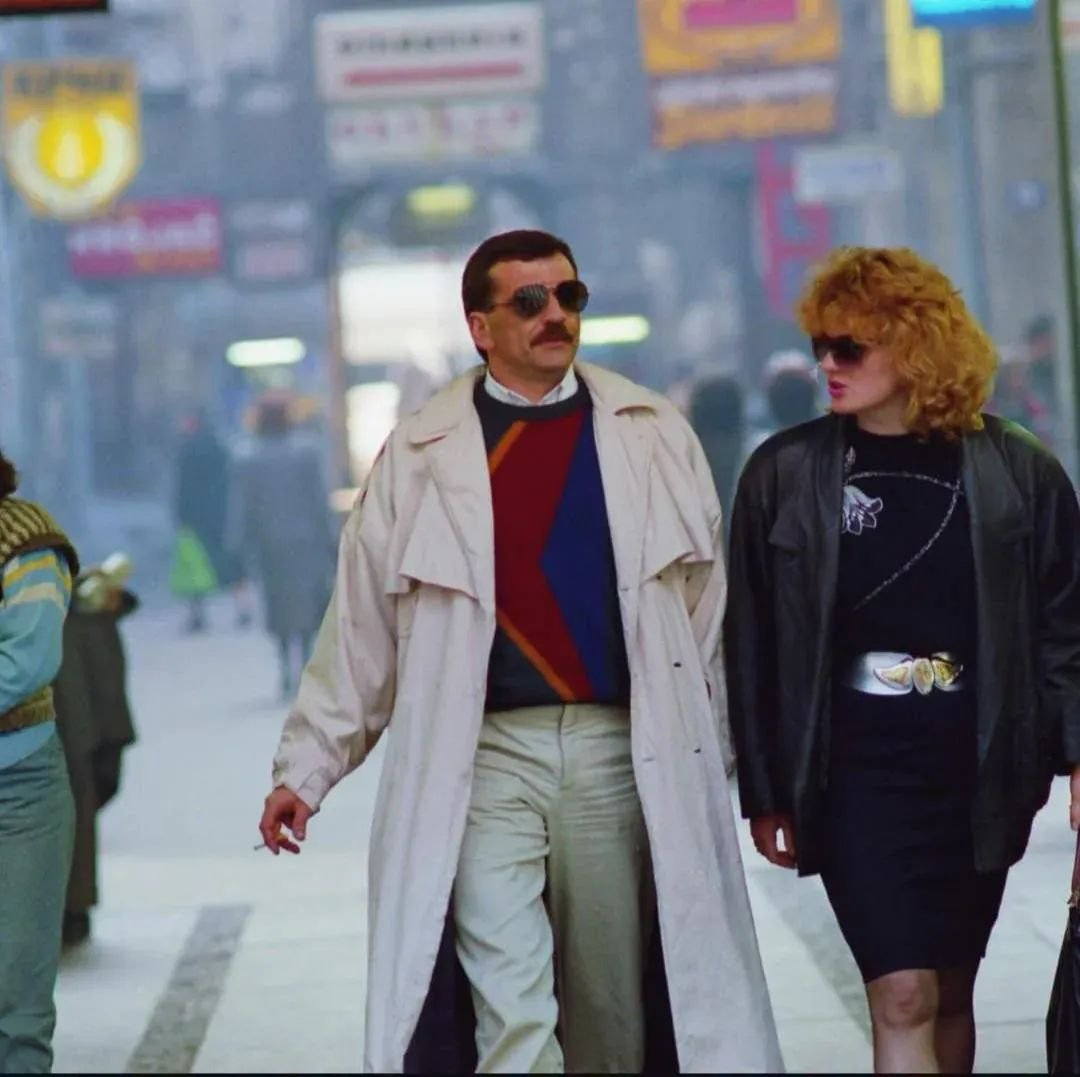 archeohistories's tweet photo. A couple striding through central Belgrade in 1988... 

At the time, Belgrade was the capital of Yugoslavia, a socialist federation of six republics that had existed in its postwar form since 1945. Josip Broz Tito, who had held the country together for decades, had died in 1980, leaving behind a rotating presidency and growing economic problems.

By 1988, Yugoslavia was deep in crisis. Inflation reached roughly 150 percent by midyear, living standards had fallen by about one-third since 1980, and the government introduced austerity measures, including a 23.9 percent devaluation of the dinar.

Belgrade became a center of worker unrest. In June, thousands marched on the federal parliament demanding higher wages and economic reforms. The following month, striking workers forced their way into the parliament building.

Meanwhile, Serbian Communist leader Slobodan Milošević was rapidly gaining political power as ethnic and regional tensions intensified. Within three years, Yugoslavia would begin breaking apart amid war.

Yugoslavia recorded 1,570 strikes involving approximately 365,000 workers in 1987 alone, nearly double the number of strikes recorded the previous year.

#archaeohistories