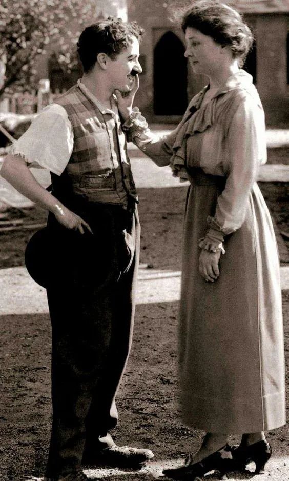 archeohistories's tweet photo. The historic photograph shows the deaf-blind American author and activist Helen Keller greeting the British silent-film comedian Charlie Chaplin by touching his face to feel his features during their meeting at Chaplin Studios, 1919... 

Keller met Chaplin while visiting his Hollywood studio during the production of Sunnyside. The Charlie Chaplin Archive preserves several images from the meeting and dates them to 1919.

Because Keller was both deaf and blind, touch was central to how she communicated and gathered information about people. She later recalled examining Chaplin's clothing, shoes and famous mustache so she could form a clearer impression of the man she knew as a movie star.

Chaplin arranged a private screening of A Dog's Life and Shoulder Arms. Anne Sullivan communicated what was happening onscreen by signing into Keller's hand, allowing Keller to follow the action and comedy. Accounts from the period reported that she laughed along with the films.

Keller was already internationally famous by this time as an author, lecturer and advocate. She was in California in connection with Deliverance, the 1919 motion picture based on her life in which she appeared as herself.

Keller taught Chaplin the tactile finger alphabet she used to communicate, reversing their expected roles: during part of their meeting, one of the world's most famous silent-film performers was learning a form of silent communication from her.

#archaeohistories
