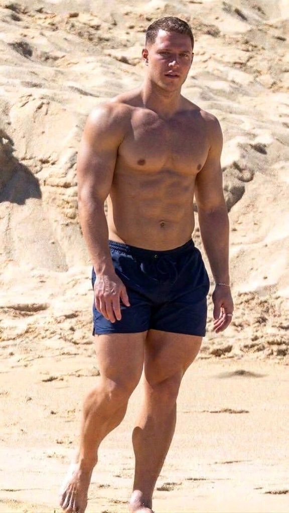 Emmy_jay231's tweet photo. NFL star Christian McCaffrey walking shirtless along a sandy beach. https://t.co/Ic0XyscMdQ