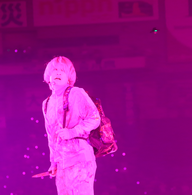 SekaiNoRascal's tweet photo. 右上にドローン
　演出を邪魔しないように、ちっこいの飛ばしてますね
DVDになったときに、どのシーンか見つけたい。

ピンクに染まった世界で、静かに見つめる両角。

背中のリュックと手元のナイフ。
優しそうな表情の奥に潜む狂気まで、映画からそのまま現れたようでした。
#両角 #Fukase #SEKAINOOWARI #映画キャラクター