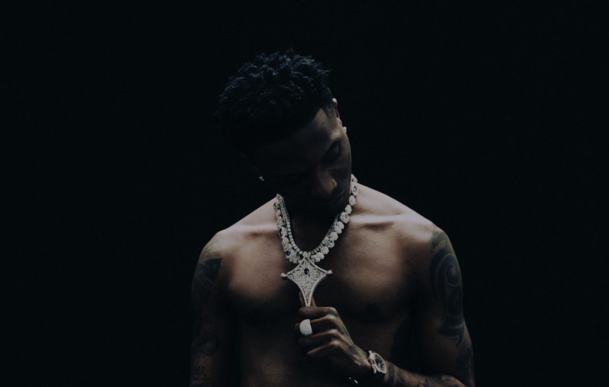 rynosas's tweet photo. The later photoshoots show the other side quieter, darker, jewellery heavy, sitting on the floor like the fame is just another room he’s in. Same face from the Made in Lagos era, just older and colder. The voice didn’t age. The image got sharper. https://t.co/wIwFPuY1yE
