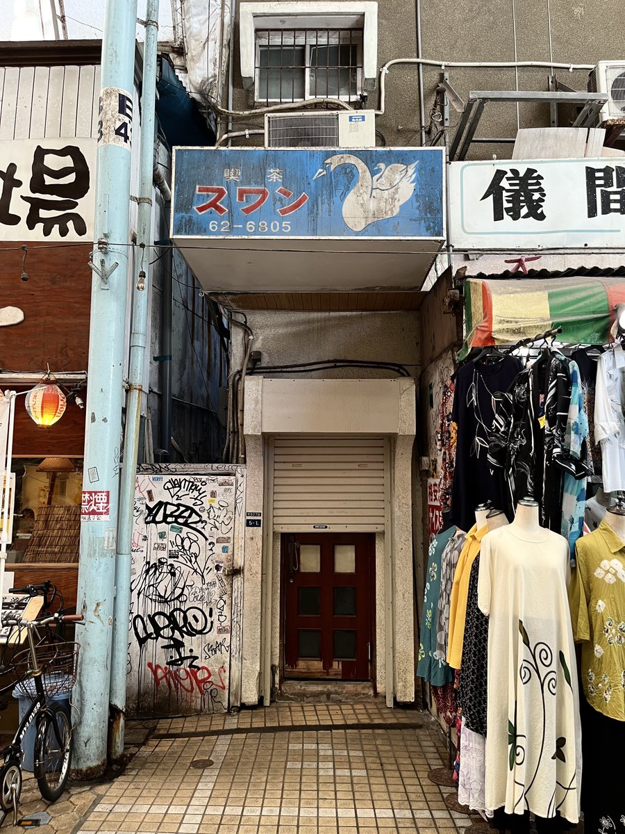 YOZORAkissa's tweet photo. #僕と喫茶と定休日に Vol.011
2026.6.21(日) 喫茶スワン(沖縄県那覇市) 前回投稿のRose Roomをさらに北へと歩き平和通り商店街へ。こちらも歴史ある佇まいで抜群の雰囲気。1階の衣料品店に押されつつある入口。これもまた商店街ならではで良い。店舗自体は2階に存在するようです。#純喫茶コレクション https://t.co/A23bcL28YL