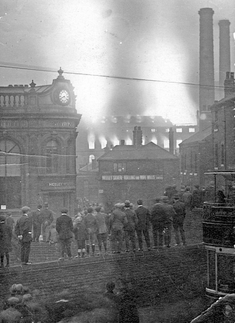 AlastairWright's tweet photo. They're standing on top of the wall of Lowfield School to get a better view of the huge fire engulfing Sheaf Bank Works, Heeley on 23rd April 1921.
The bank building with the clock is now Heeley Antiques Centre. #Sheffield https://t.co/DyhRwKoMjD