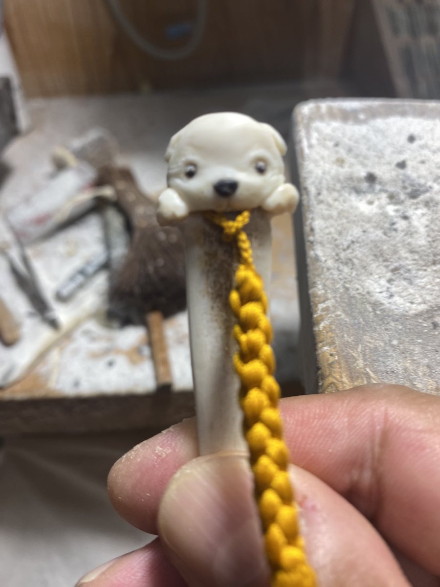 kenjimori4's tweet photo. 以前、帯飾りをお迎えくださったお客様から、
「帯飾りに合わせる鹿角の帯挿しも、森さんらしいものを作ってほしい」とご依頼いただきました。

作品制作の合間に、こんな感じかなと考えながら、仔犬が紐をくわえている形にしています。

帯に挿すと、紐の先の提げ物を仔犬が覗き込んでいるように見えるかなと思っています。

小さな帯挿しですが、こういう少し���びのあるものを作るのも楽しいです。