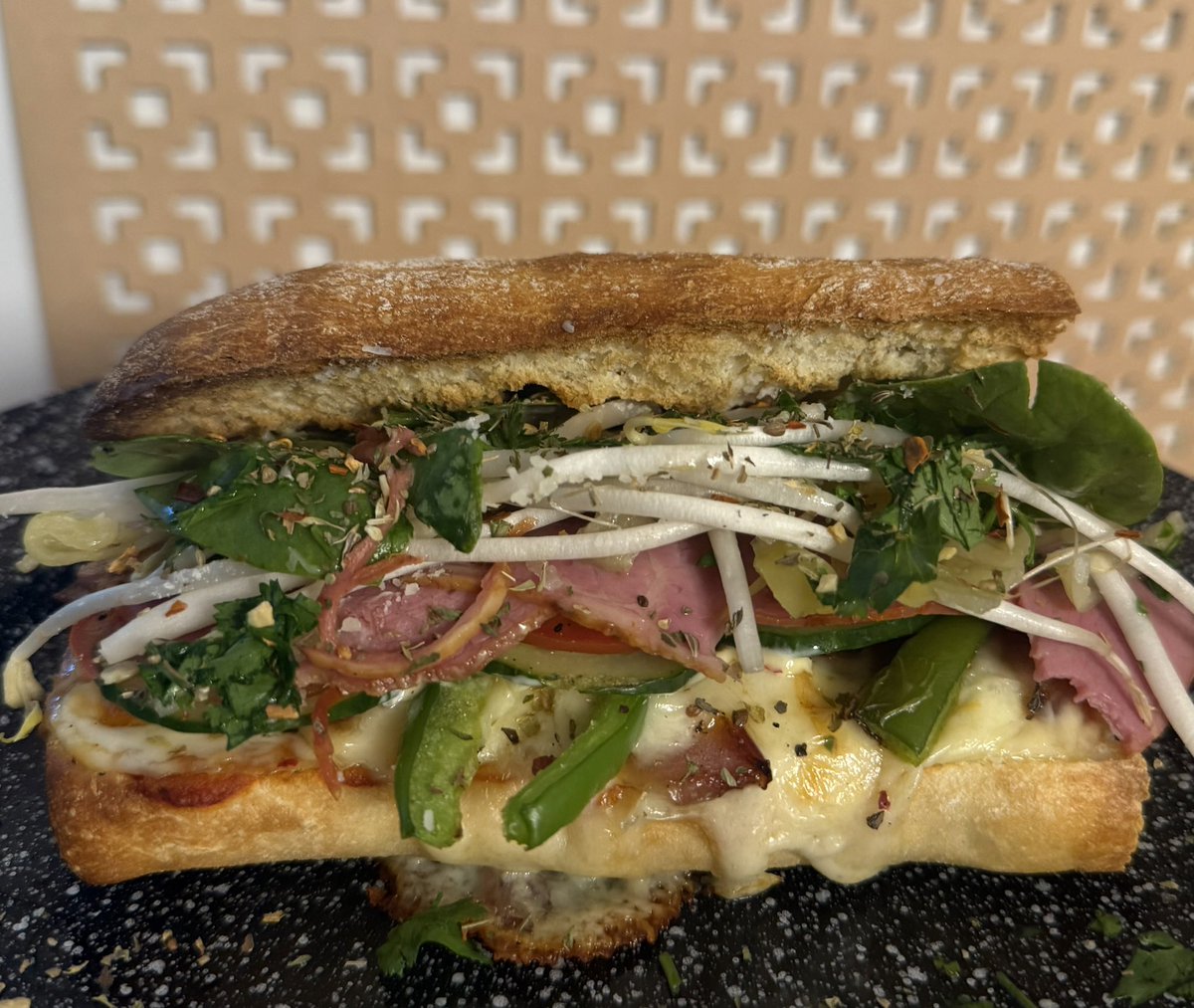 beepbat's tweet photo. Hot capocollo, pastrami, marinara, mozzarella, fried onions, pepperoncini, spinach, green pepper, been sprouts, fresh cilantro, tomato, cucumber, spices, Parmesan, a little mayo and a little oil dressing on ciabatta. I might have peaked in my sandwich making career https://t.co/z0OShl1S4q