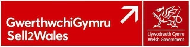 A red sign for Sell2Wales featuring the Welsh Government logo and an arrow pointing upwards to the right.
