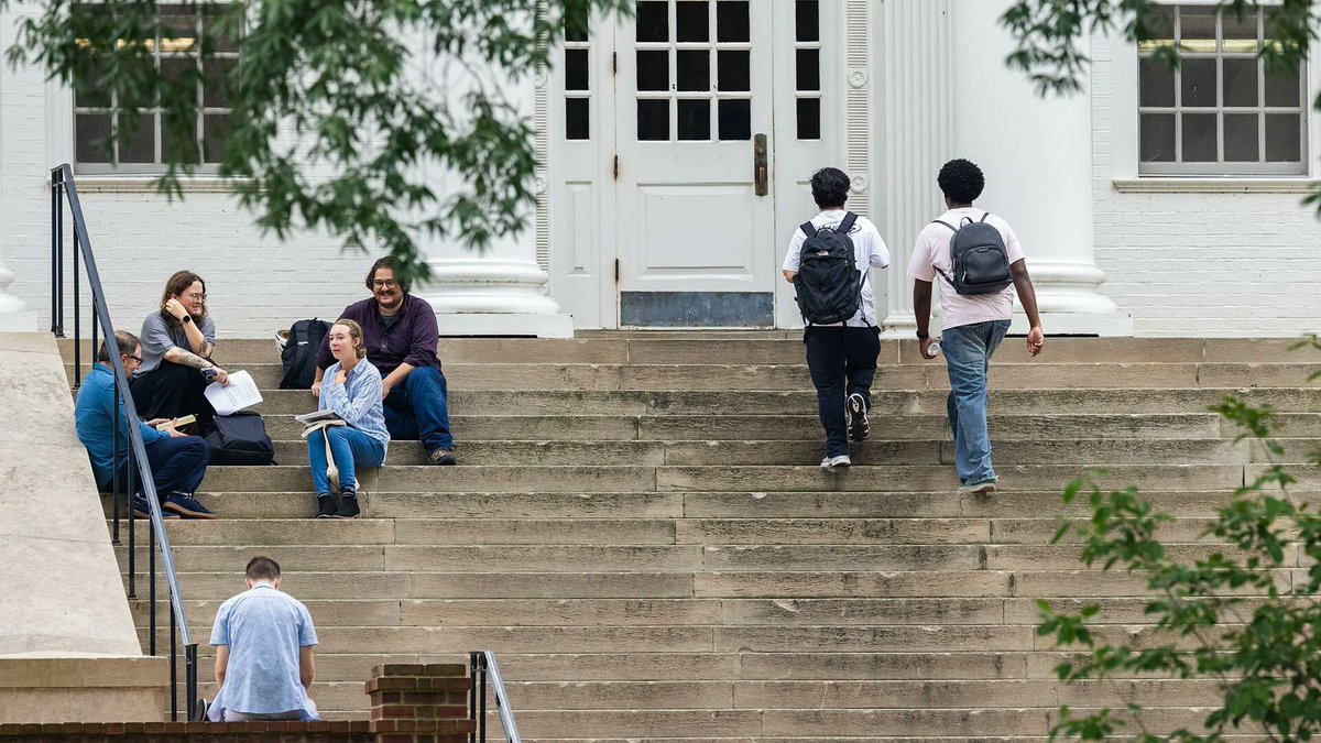 Students sit on the steps of a building at UMD.