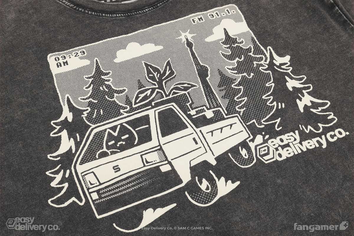 A photo of a stone-washed black t-shirt with an off-white Easy Delivery Co. design. The "easy delivery co." logo is on the bottom right, with a character in a kei truck popping out of a design featuring trees with dot shading, a communications tower, and the time (9:29 AM) and radio station (91.1 FM) in each upper corner.